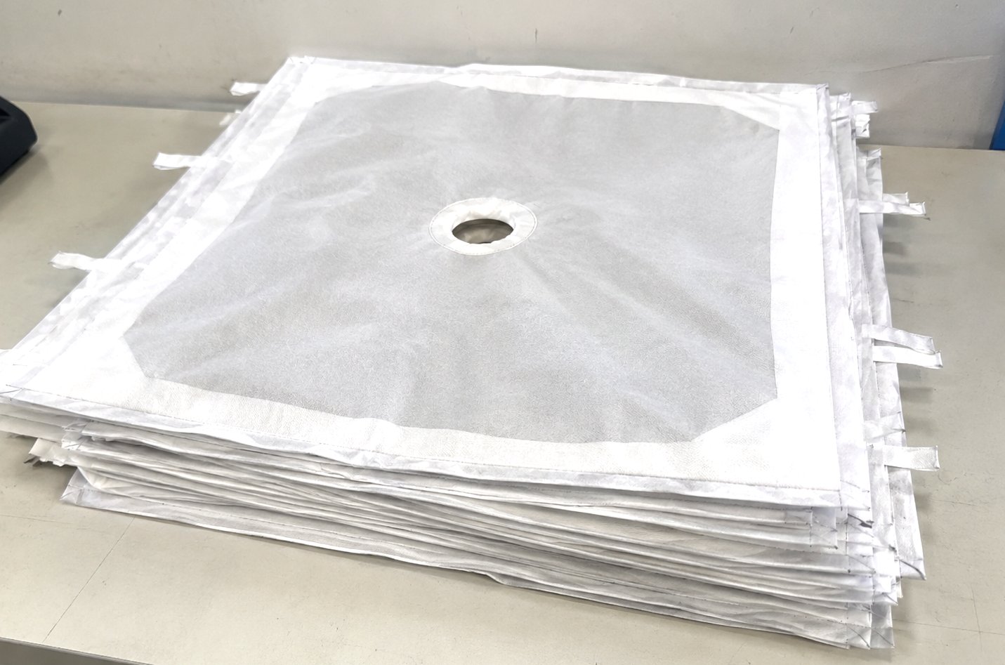 Filter cloths: stack of custom filter press cloths with centre feed holes and tie straps