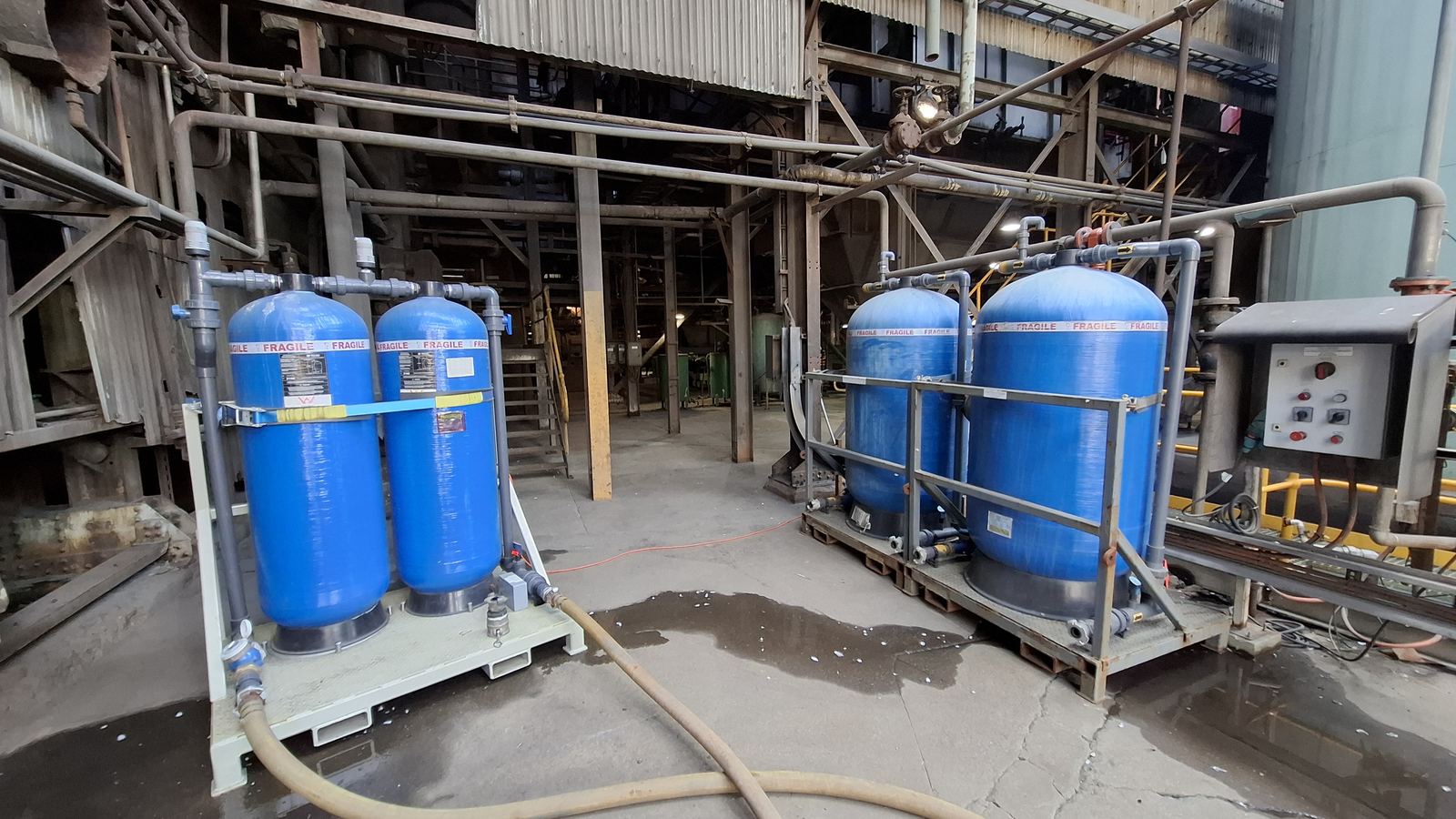 Pre-charged standby ion exchange vessels on skids, connected inside an industrial plant room