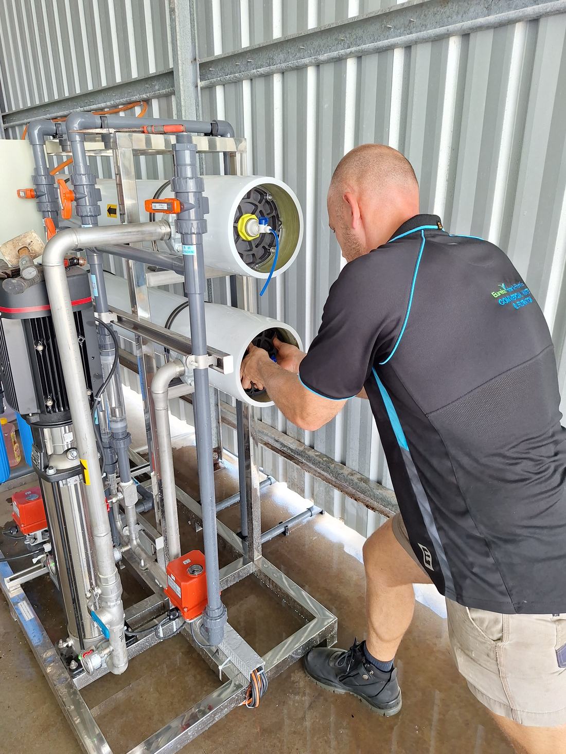Eureka Water & Filtration technician servicing reverse osmosis membrane housings on site